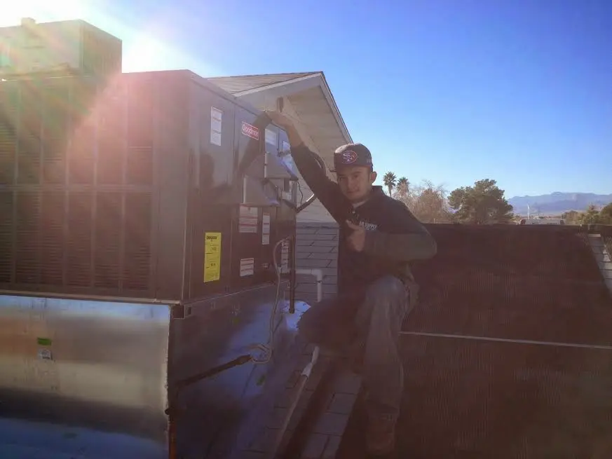 HVAC technician performing Heat Pump Repair on a rooftop unit in Granby